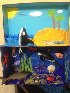 an ocean scene made out of cardboard with dolphins and other marine creatures