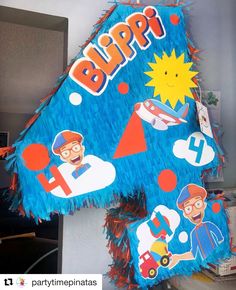 a large blue birthday decoration with cartoon characters on it's face and letters that spell out the word blipp