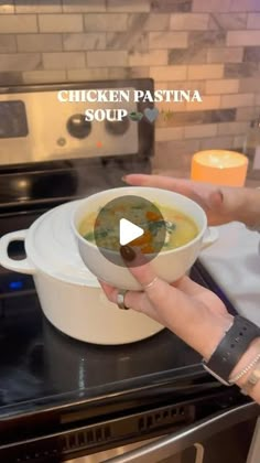 a person holding a bowl of soup in front of an oven with the words chicken pasta soup on it