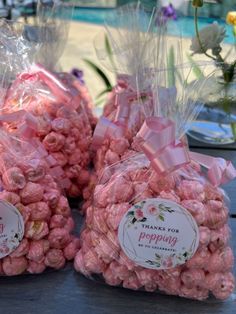 three bags of pink popcorn sitting on top of a table