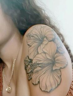 a woman with a flower tattoo on her arm and shoulder is looking at the camera