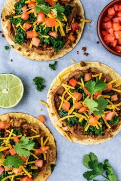 three tortillas topped with meat, cheese and veggies next to a bowl of salsa