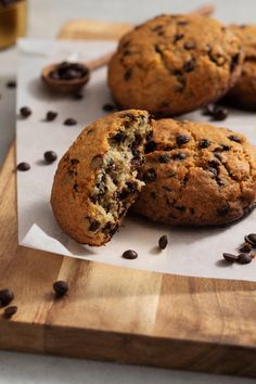 two chocolate chip muffins cut in half on a cutting board with coffee beans