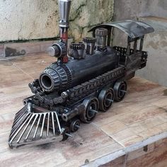 a toy train sitting on top of a wooden table next to a cement block wall