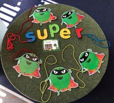 a table topped with cut out magnets on top of a green plate covered in writing