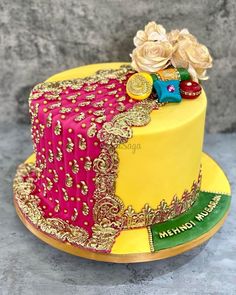 a yellow and pink cake with flowers on top