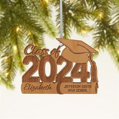 a wooden ornament with a graduation cap and tassel hanging from a christmas tree