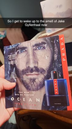 a person holding up a magazine with an ad for the perfume brand ocean on it