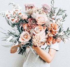 a woman holding a large bouquet of flowers