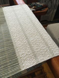 a close up of a table cloth on top of a wooden chair in a room