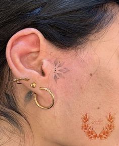 a close up of a person's ear with tattoos on it