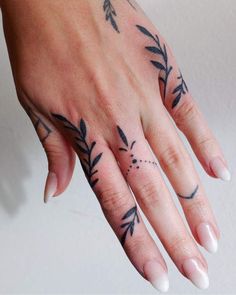 a woman's hand with tattoos on it and an arrow tattoo on the middle finger