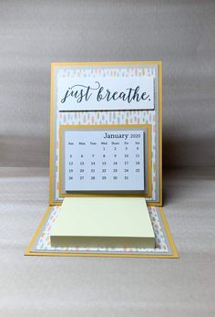 a desk calendar with the word first breathe written in black ink on top of it