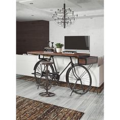 a bicycle is parked in front of a desk with a computer on it and a chandelier hanging from the ceiling