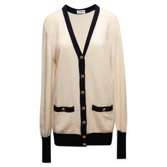 Vintage cream and black color block cashmere cardigan by Chanel. Circa 1980s. V-neck. Dual hip pockets. Gold-tone button closures at center front. 40" bust, 18" shoulder width, 32" length.