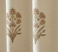 an embroidered curtain with flowers and leaves on it