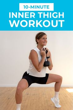 a woman in black shorts and white tank top doing an exercise with dumbbells