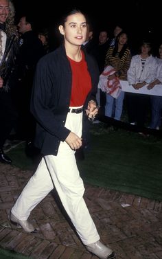 a man in white pants and a red shirt is walking