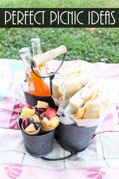 two buckets filled with food sitting on top of a blanket