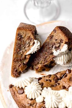 a piece of chocolate chip cookie cake on a plate with white frosting and chocolate chips