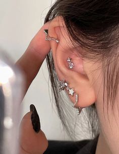 a woman is getting her ear pierced with stars