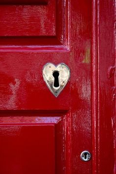 a red door with a heart shaped keyhole