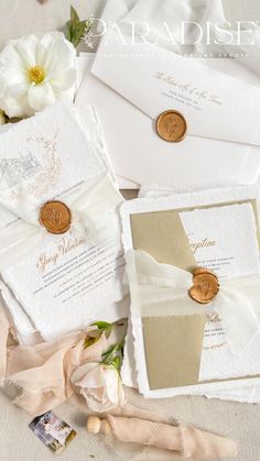 the wedding stationery is laid out on top of the table with flowers and ribbons