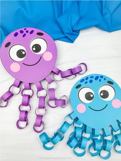 two paper cutouts of octopus and jellyfish on a bed