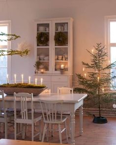 a dining room table and chairs with candles on it