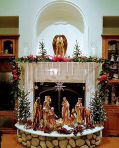 a fireplace decorated with christmas decorations and figurines