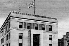 an old black and white photo of a building with a flag on the top of it