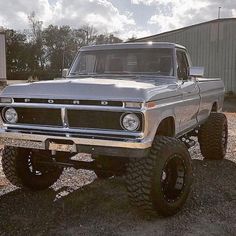 an old pickup truck is parked in the gravel