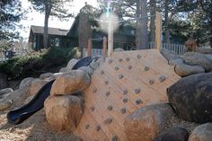 an outdoor play area with rocks and a slide