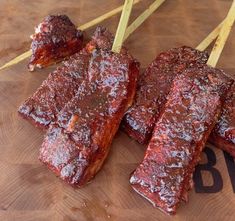 some ribs are sitting on a cutting board with toothpicks