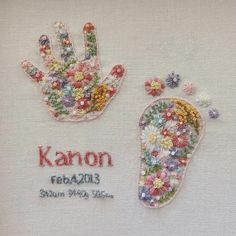 two embroidered hand and foot prints on a white cloth with the words karon written in red