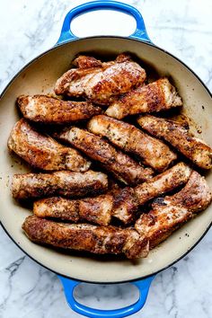 chicken wings in a blue pan on a marble counter top