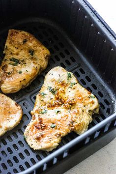 three pieces of chicken sitting on top of a grill