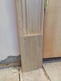 a wooden door with a metal handle on the front and side of it is being worked on