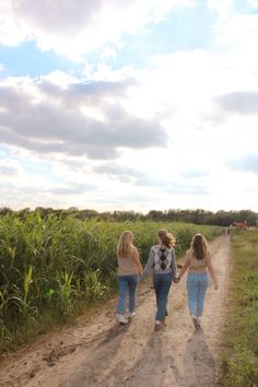 two women walking down a dirt road holding hands