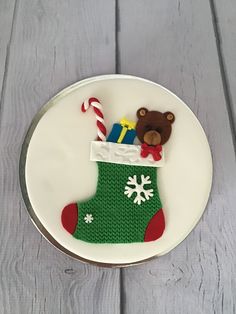 a cake decorated with a christmas sock and teddy bear