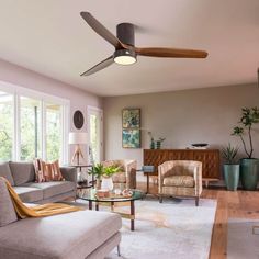 a living room with couches, chairs and a ceiling fan in it's center