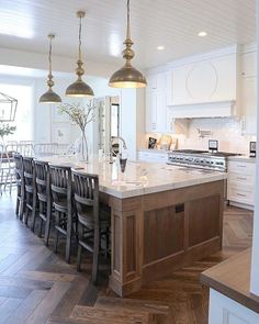 a large kitchen with an island in the middle and lots of counter space on one side