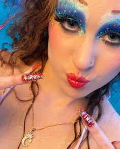 a woman with blue and red makeup posing for the camera