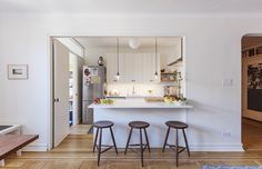 a kitchen with three stools in it