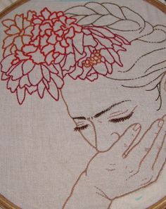 a close up of a embroidery on a piece of cloth with a woman's face