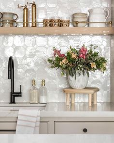 a kitchen counter with flowers in a vase on it