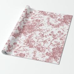 a pink and white floral wrapping paper on top of a table with an empty roll