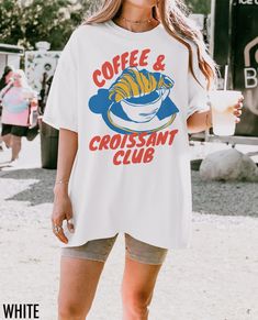 Introducing our vintage inspired Coffee & Croissant Club graphic tee, featuring a retro coffee and croissant graphic. We use professional quality DGT printing on all our apparel. Direct-to-garment, or DTG, is a high quality printing method that sprays ink directly onto the garment so there is no peeling or cracking. This fabulous graphic will be printed on a Comfort Colors Unisex T-Shirt. Please refer to the size charts in the images for the best fit.  Estimated Production Time: 1-5 days Estimat Food Shirt Design, Summer Merch, Coffee T Shirt, Outfit Basic, Swag Design, Croissant Breakfast, Trendy Tees, Food Shirt, Retro Coffee