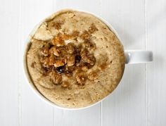 an overhead view of a bowl of oatmeal on a white table top