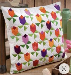 a colorful pillow sitting on top of a wooden table